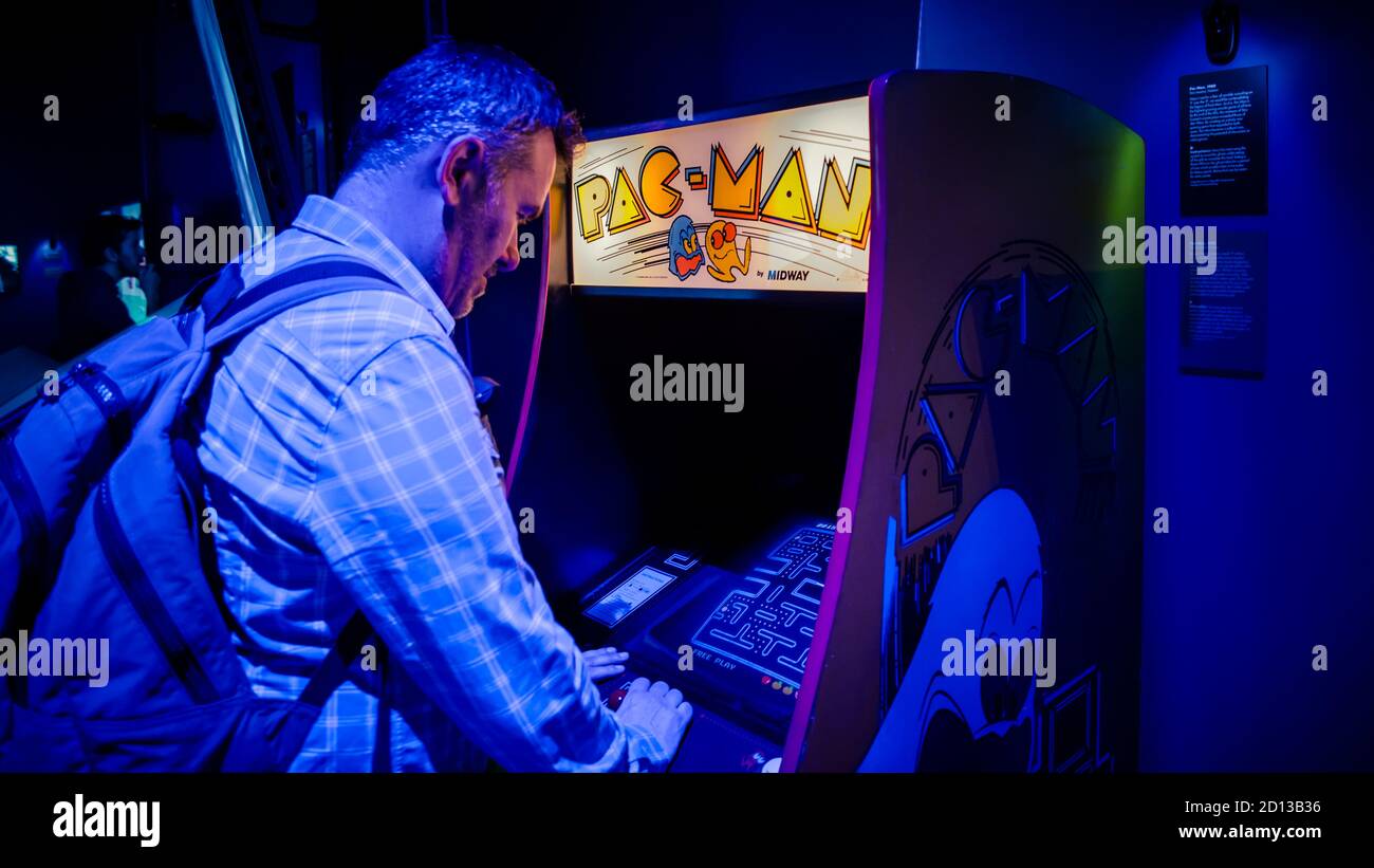 Istanbul, Turquie - février 2016: L'homme jouant avec PAC Man arcade console de jeux vidéo Banque D'Images