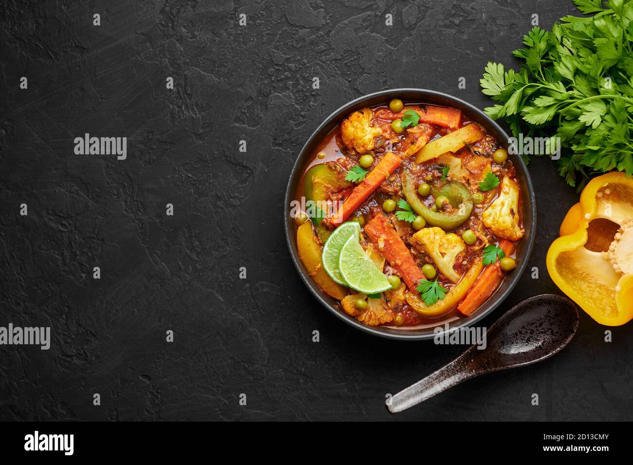 Veg Kolhapuri dans un bol noir sur table en ardoise sombre. Plat de curry de légumes indiens. Plats et repas asiatiques végétariens. Copier l'espace. Vue de dessus Banque D'Images