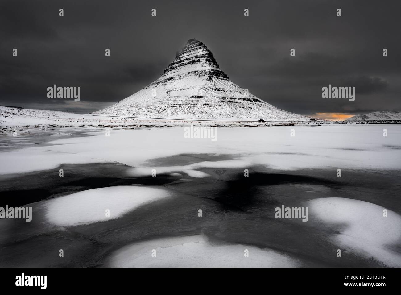 Le célèbre Kirkjufell est tombé sur une matinée d'hiver sombre avec une zone colorée de lever du soleil en toile de fond. Banque D'Images