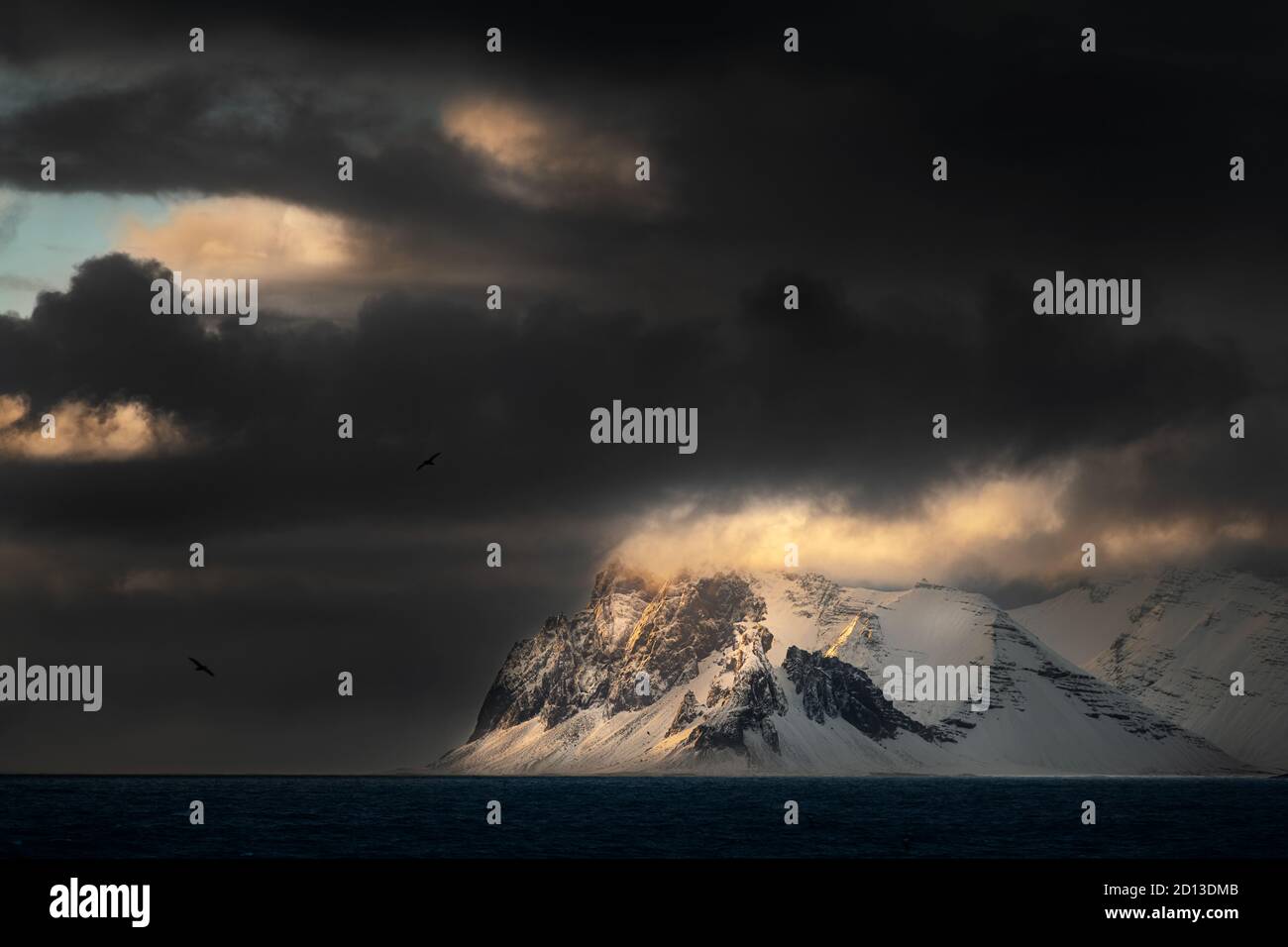 Des nuages sombres et un peu de lumière lors d'une matinée de tempête au fjord Lonsvik. Banque D'Images