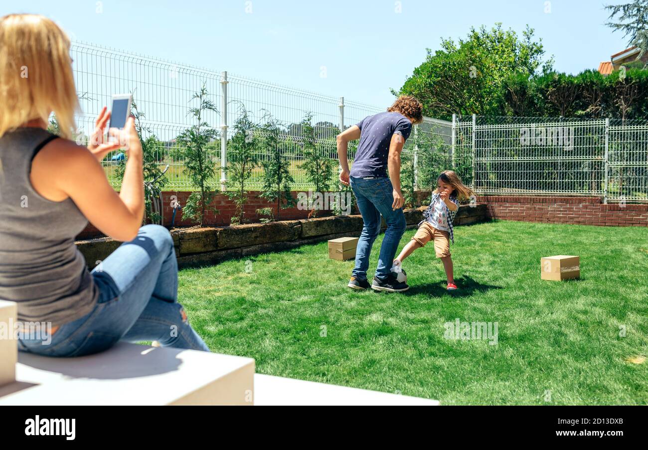 Mère de prendre photo de son mari et son fils jouer Banque D'Images