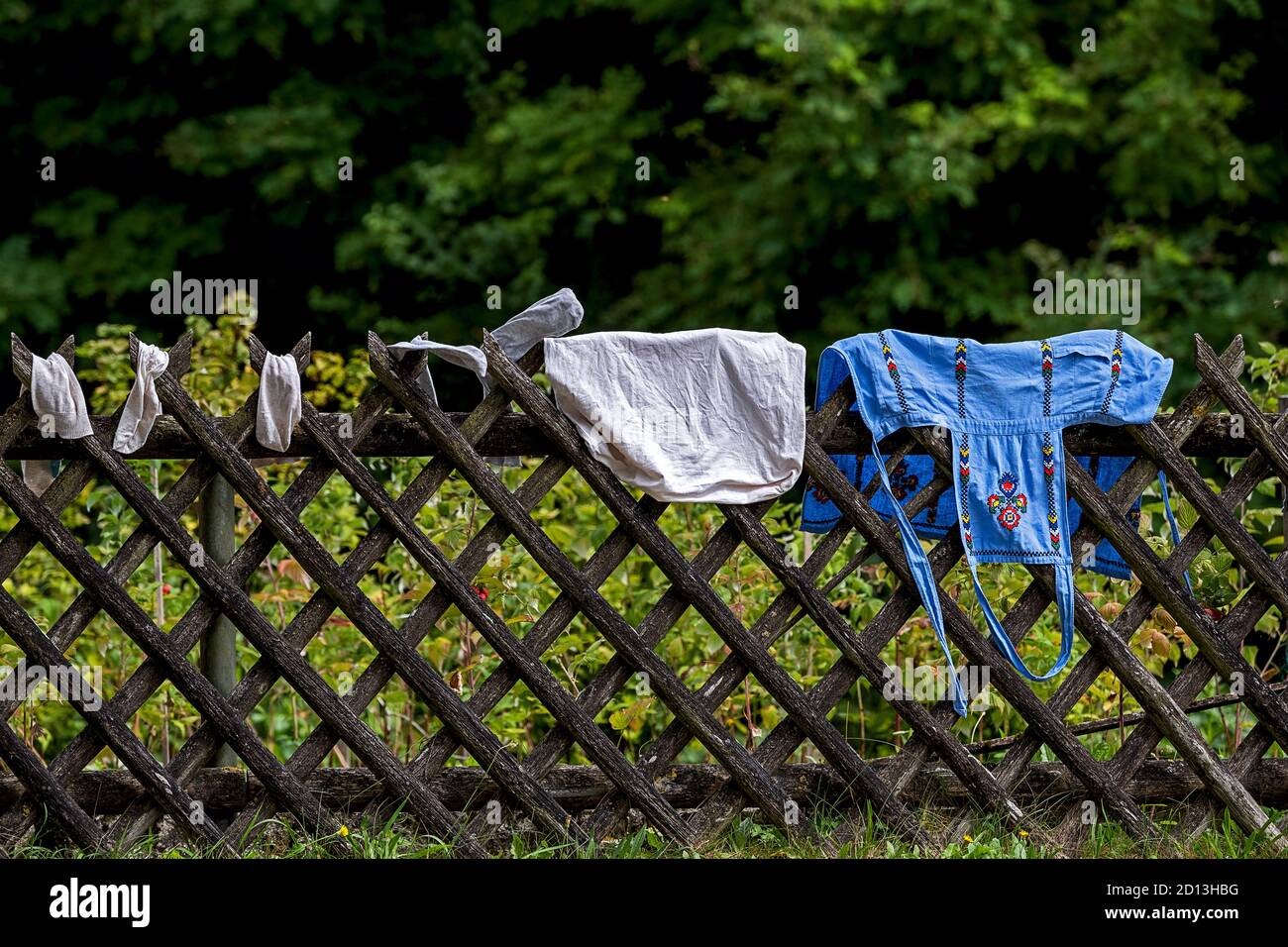 joli tablier de cuisine brodé, oreiller et chaussettes accrochés pour sécher sur une clôture Banque D'Images