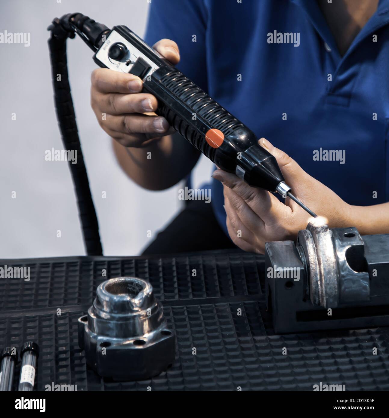 Les travailleurs industriels utilisent le dispositif de revêtement/revêtement laser Electro-Spark pour remplacer la pièce à usiner usée Banque D'Images