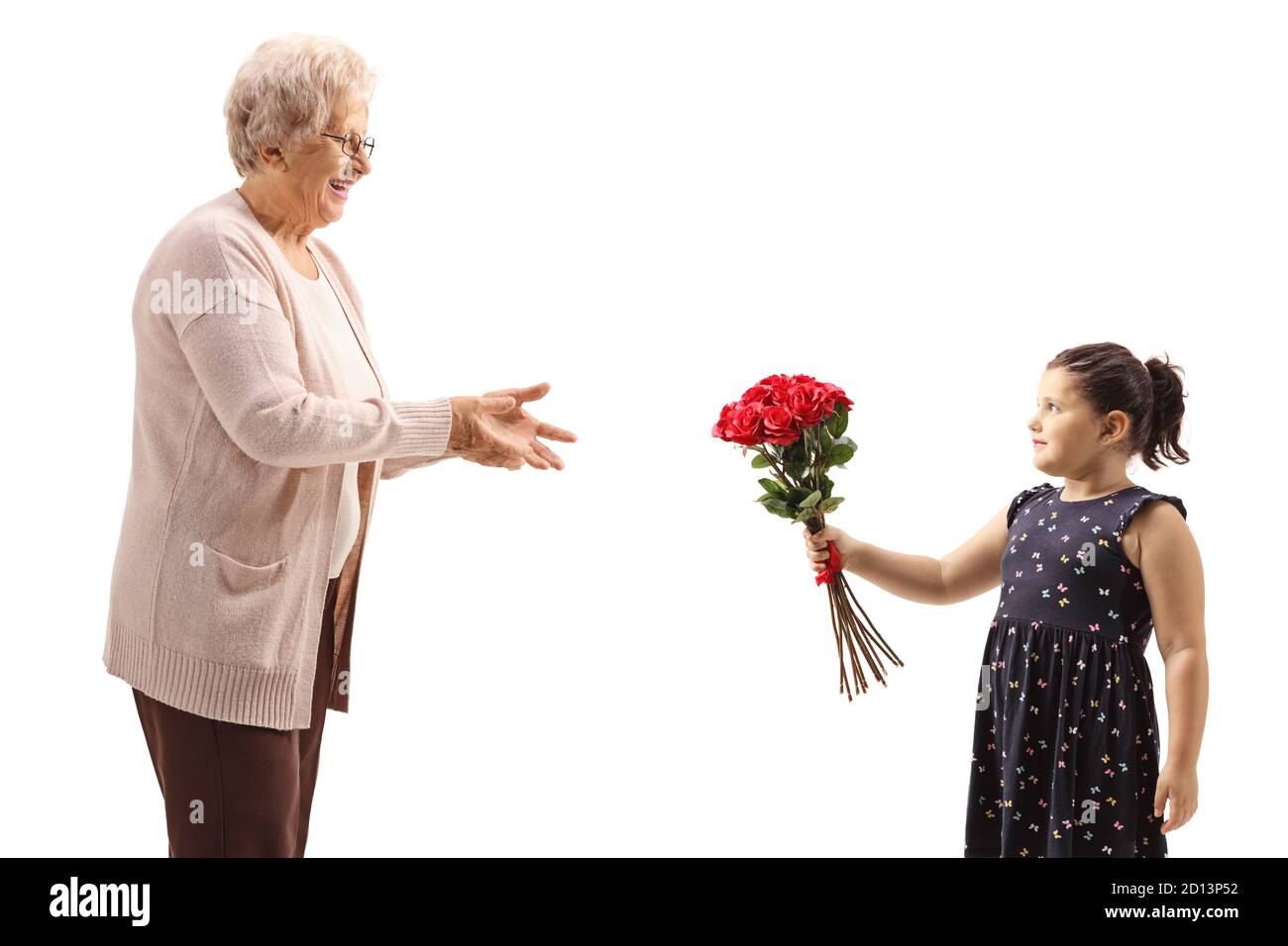 Fille donnant un bouquet de roses rouges à une grand-mère isolé sur fond blanc Banque D'Images