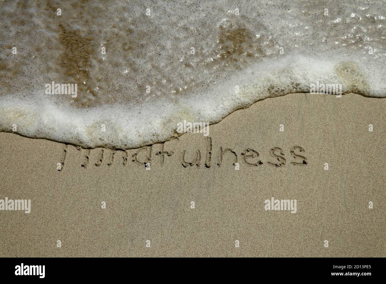 Concept de mindfulness, conscient vivant, du texte écrit sur le sable de plage Banque D'Images