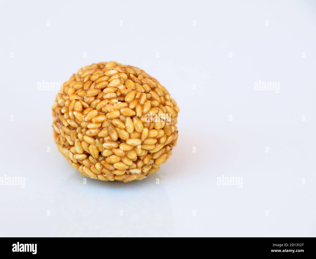 Balles de graines de sésame blanc faites de jiggery chauffé, bonbons savoureux et nourrissants, sur fond blanc Banque D'Images