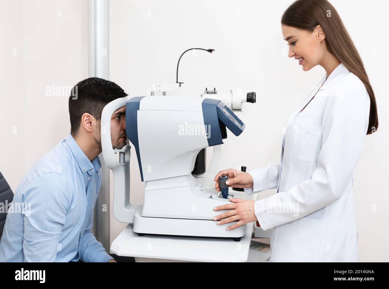 Optométriste vérifiant la vision des patients à la clinique moderne Banque D'Images