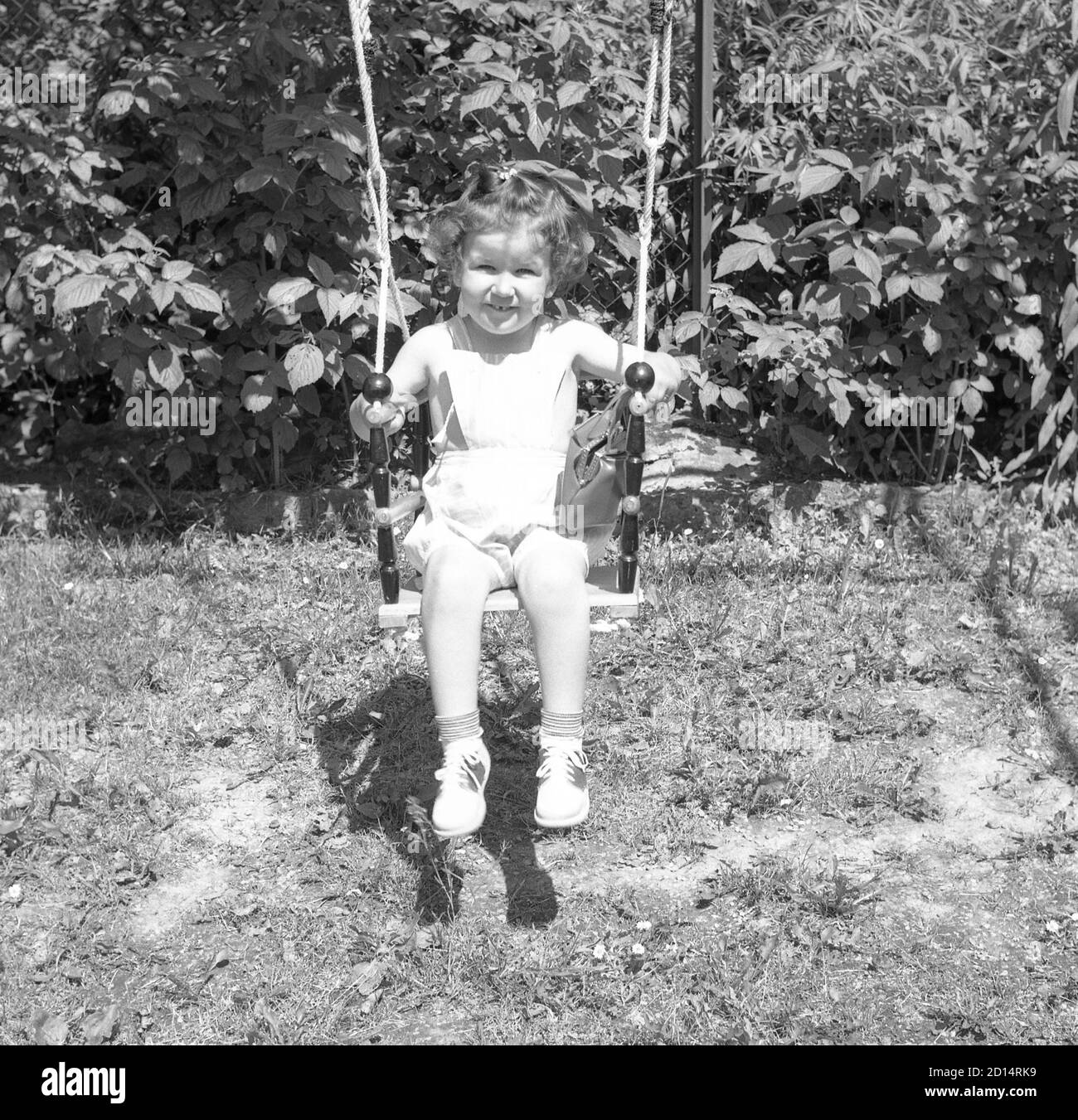 Une jeune fille des années 1950 sur une balançoire, États-Unis Banque D'Images