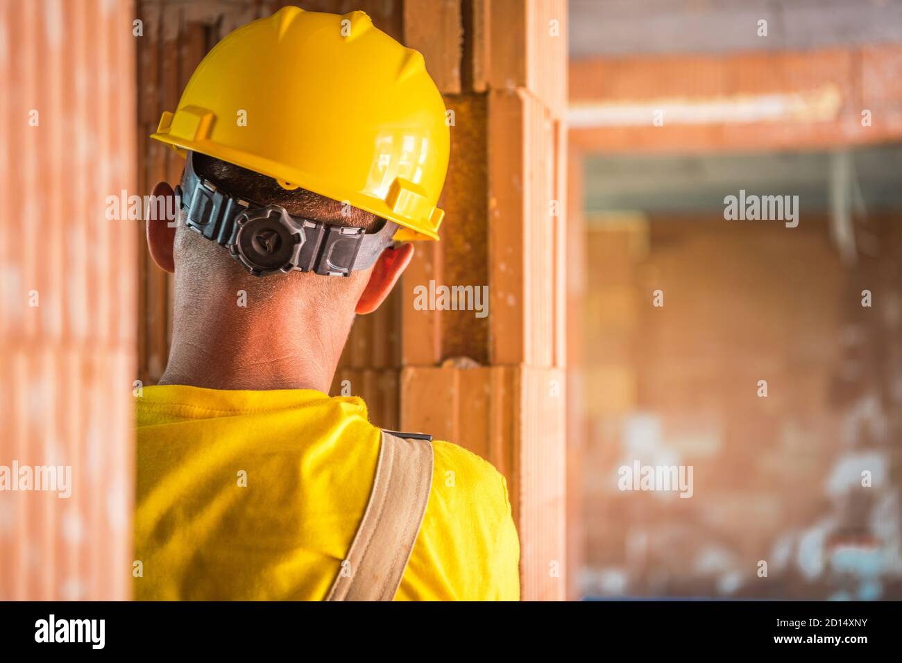 Travailleur de la construction dans ses 40 ans portant un chapeau rigide jaune gros plan. Thème de travail de l'industrie de la construction. Banque D'Images