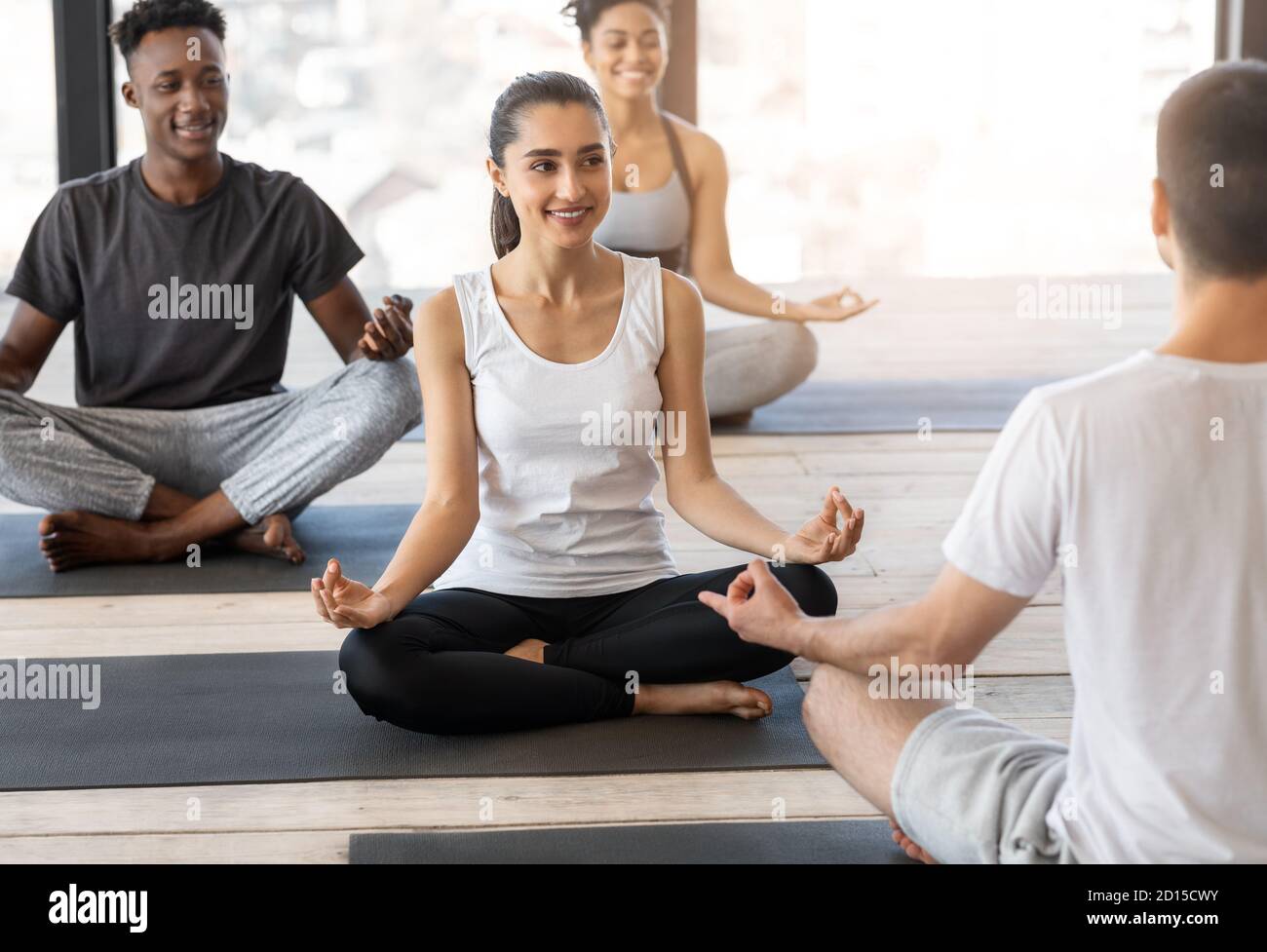 Joyeux jeunes multiethniques Attenting Group Yoga Lesson avec instructeur Banque D'Images