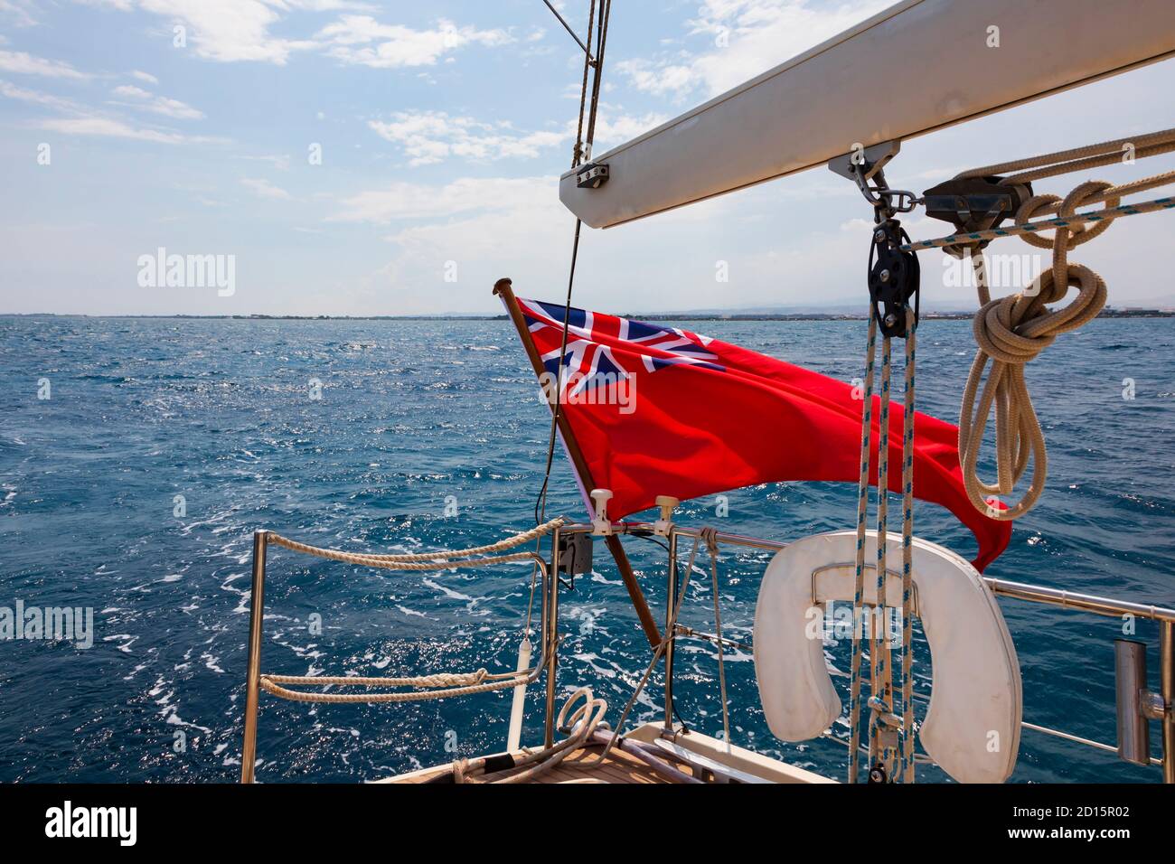 Drapeau britannique Red Ensign volant sur la poupe d'un yacht sous la voile dans la mer Méditerranée, au large de la côte de Chypre. Chypre Banque D'Images