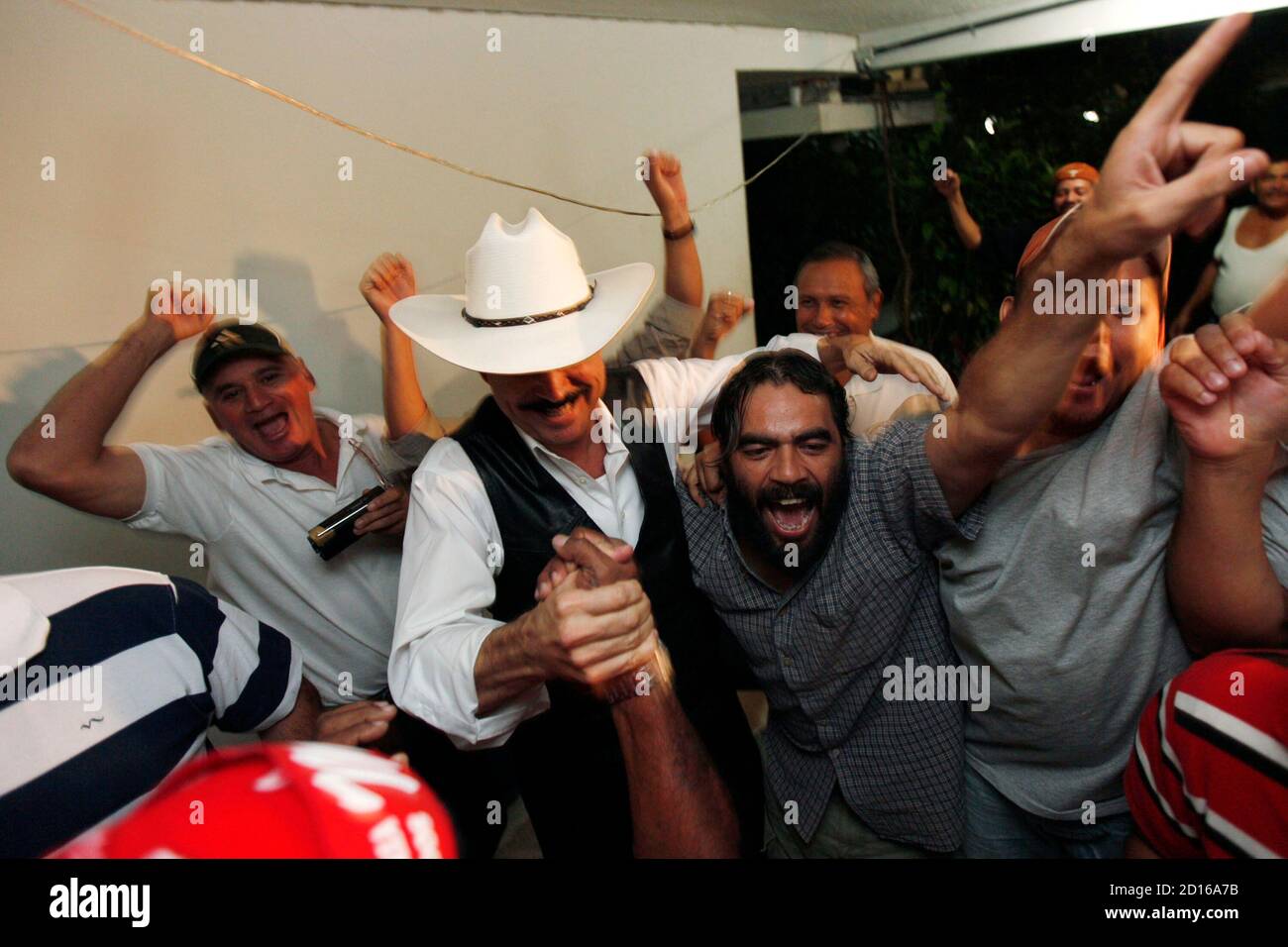 Ousted Honduras' President Manuel Zelaya (C) celebrates with supporters after Honduras' 2010 World Cup qualifying match victory over El Salvador, inside the Brazilian embassy in Tegucigalpa October 14, 2009. REUTERS/Edgard Garrido (HONDURAS POLITICS SPORT) Banque D'Images
