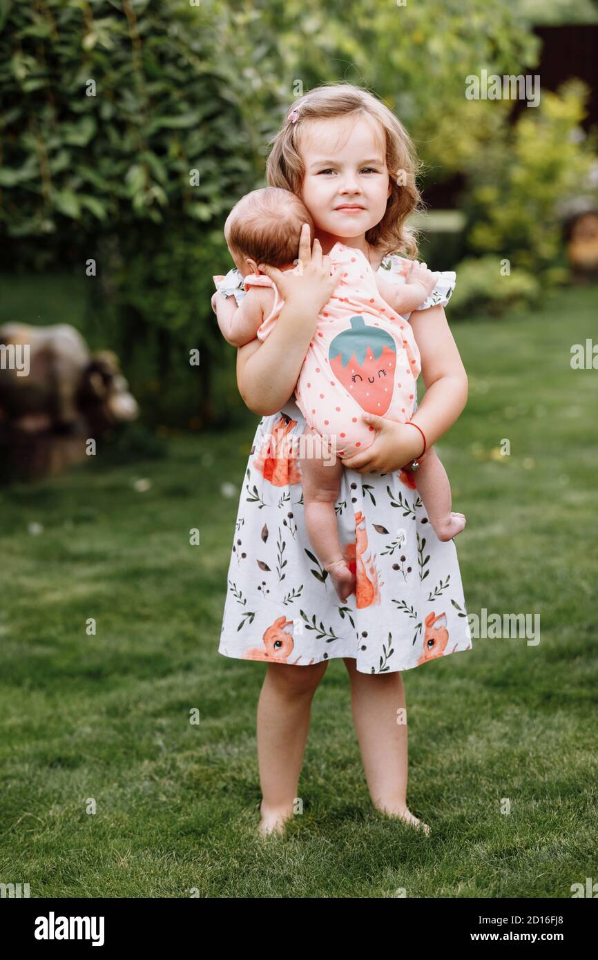 Une Petite Fille Mignonne Tient Une Sœur De Nouveau Ne Dans Elle Bras Et Passer Du Temps Heureux Avec Elle A L Exterieur Photo Stock Alamy Une Petite Fille Mignonne Tient Une Sœur De Nouveau Ne Dans Elle Bras Et Passer Du Temps Heureux Avec Elle A L Exterieur Photo Stock Alamy