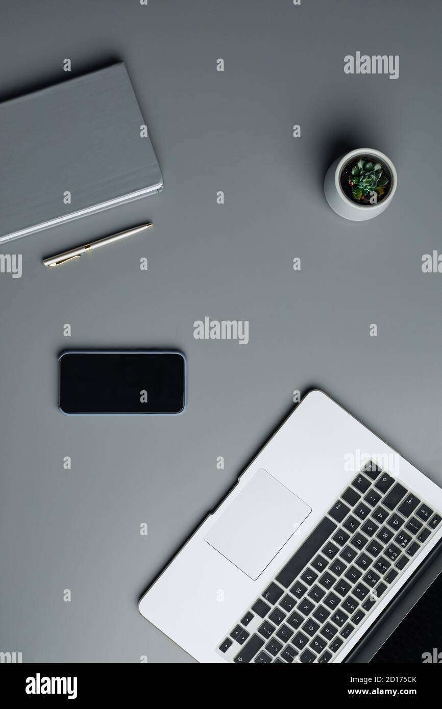 Au-dessus de la vue, un écran plat d'ordinateur portable et de gadgets professionnels sur un arrière-plan gris du lieu de travail, un espace de copie Banque D'Images