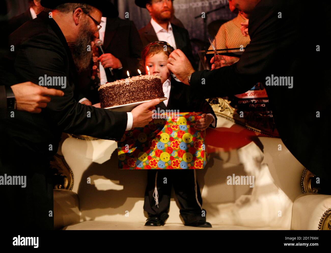 Ultra-Orthodox Jews cut the hair of Moishe Holtzberg, and present him with  presents and a cake during the Halake ceremony in Kfar Chabad, near Tel  Aviv, November 18, 2009. Moishe is the