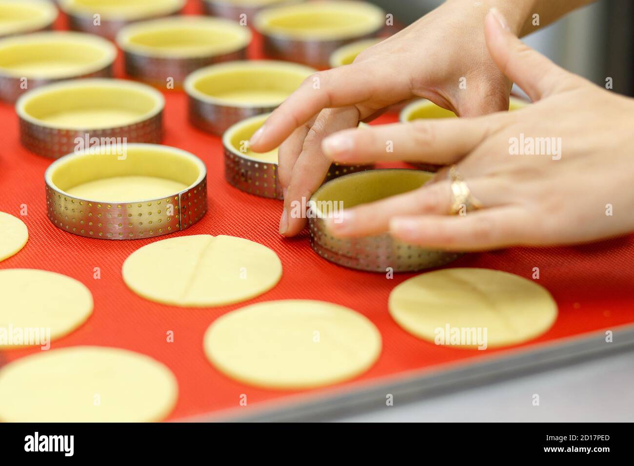 Préparer des tartes et des quiches sucrées ou salées. Cuisine nationale française. Fait à la main. Formation à la cuisine. Le cuisinier remplit le plat de cuisson avec la garniture. C Banque D'Images