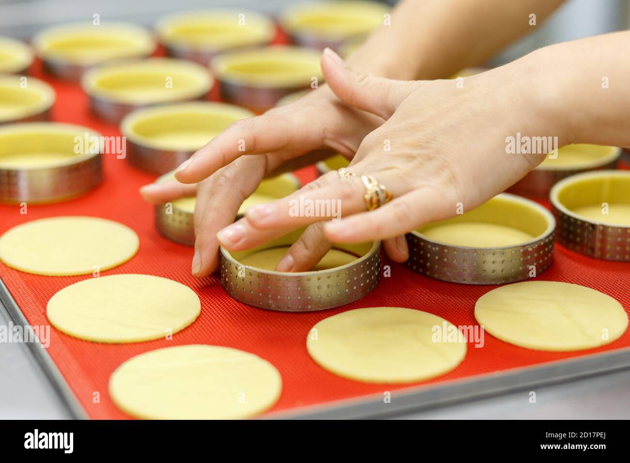 Préparer des tartes et des quiches sucrées ou salées. Cuisine nationale française. Fait à la main. Formation à la cuisine. Le cuisinier remplit le plat de cuisson avec la garniture. C Banque D'Images