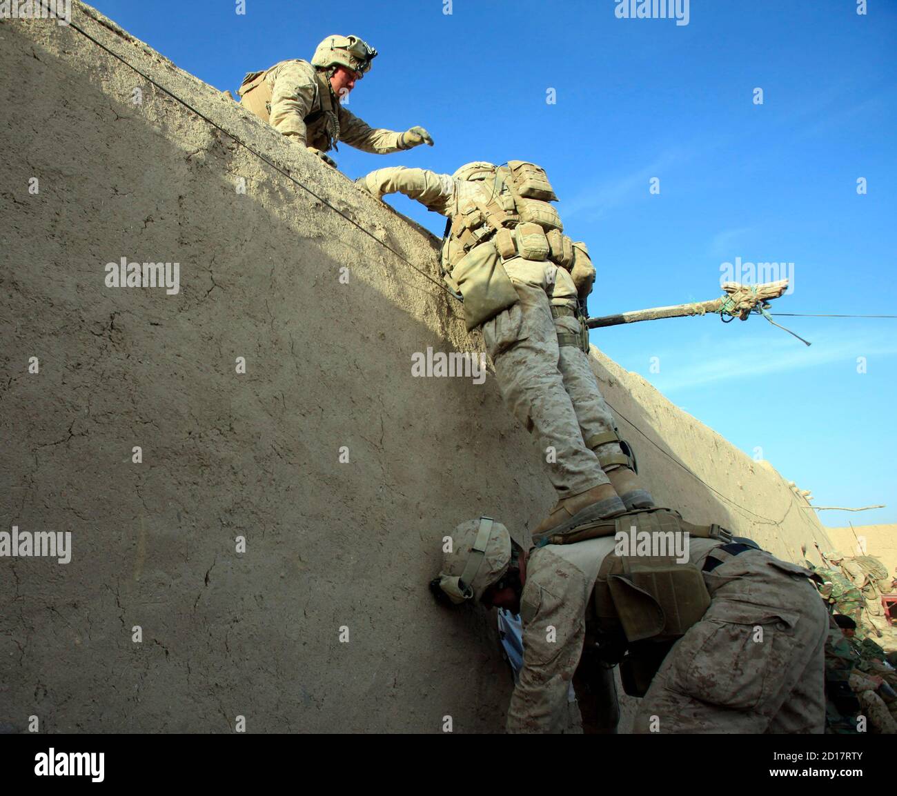 Les Marines des États-Unis de la Compagnie Bravo du 1er Bataillon, 6e les Marines grimpent un mur pendant une opération dans la ville de Marjah, dans le district nad Ali de la province de Helmand le 16 février 2010. Les Marines des États-Unis, à la tête de l'une des plus grandes offensives de l'OTAN contre les militants islamistes talibans en Afghanistan, font face à une résistance féroce dans certaines régions, enlisées par de gros coups de feu, des tireurs d'élite et des pièges. REUTERS/Goran Tomasevic (AFGHANISTAN - Tags: CONFLIT POLITIQUE MILITAIRE) Banque D'Images