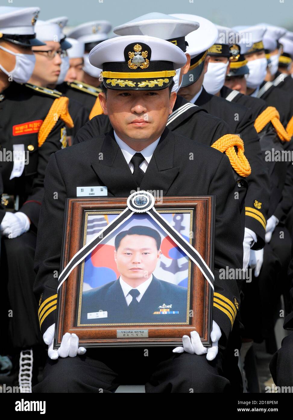 Choi Won-il, captain of the sunken South Korean naval ship Cheonan, holds a  portrait of a deceased sailor during a funeral ceremony at a naval base in  Pyeongtaek, 70 kilometres (44 miles)