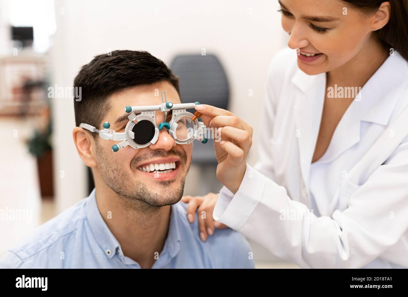Ophtalmologiste vérifiant la vision du patient avec le cadre d'essai Banque D'Images