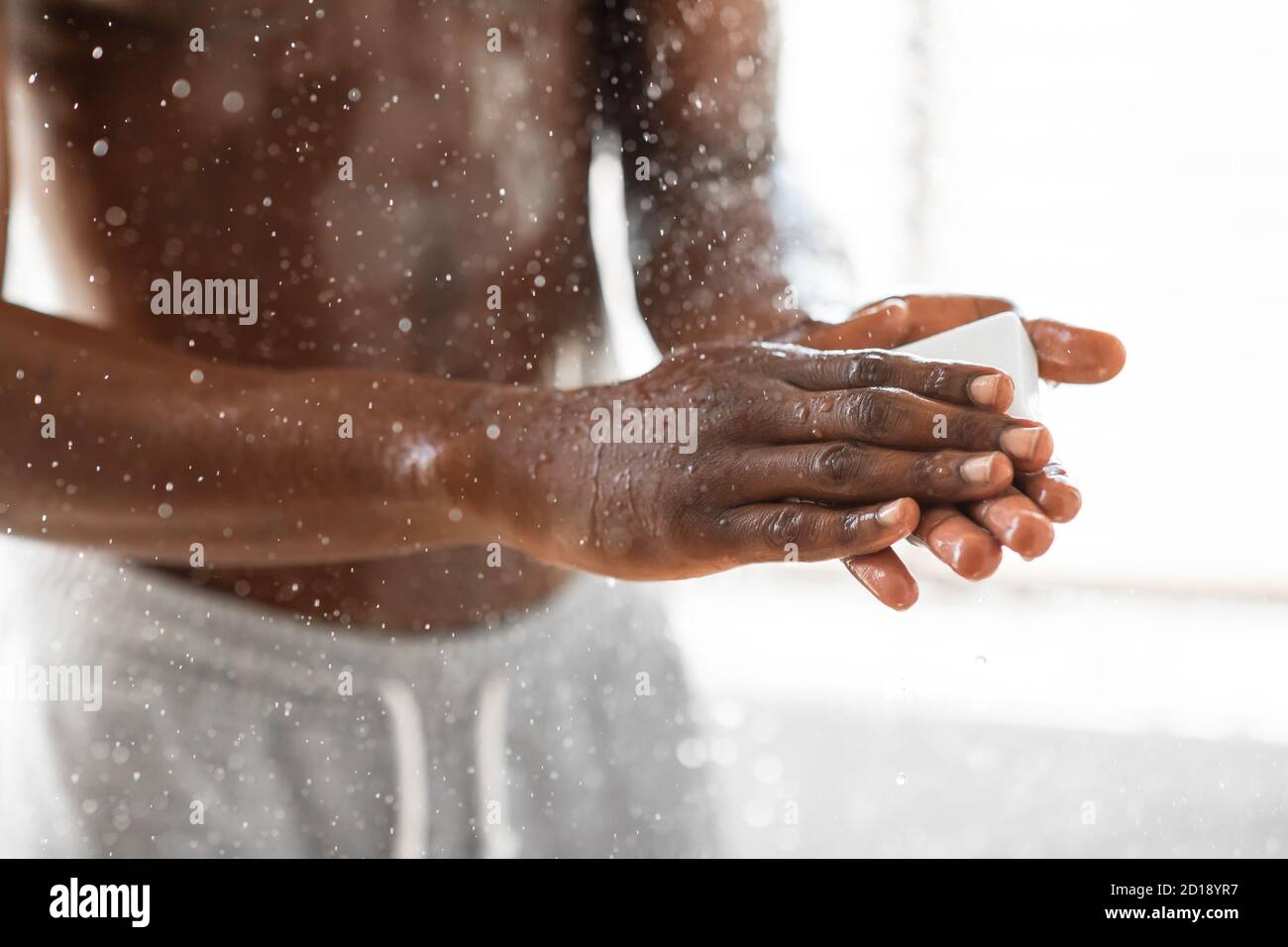 Homme noir se laver les mains avec du savon prendre une douche dans la  salle de bains Photo Stock - Alamy