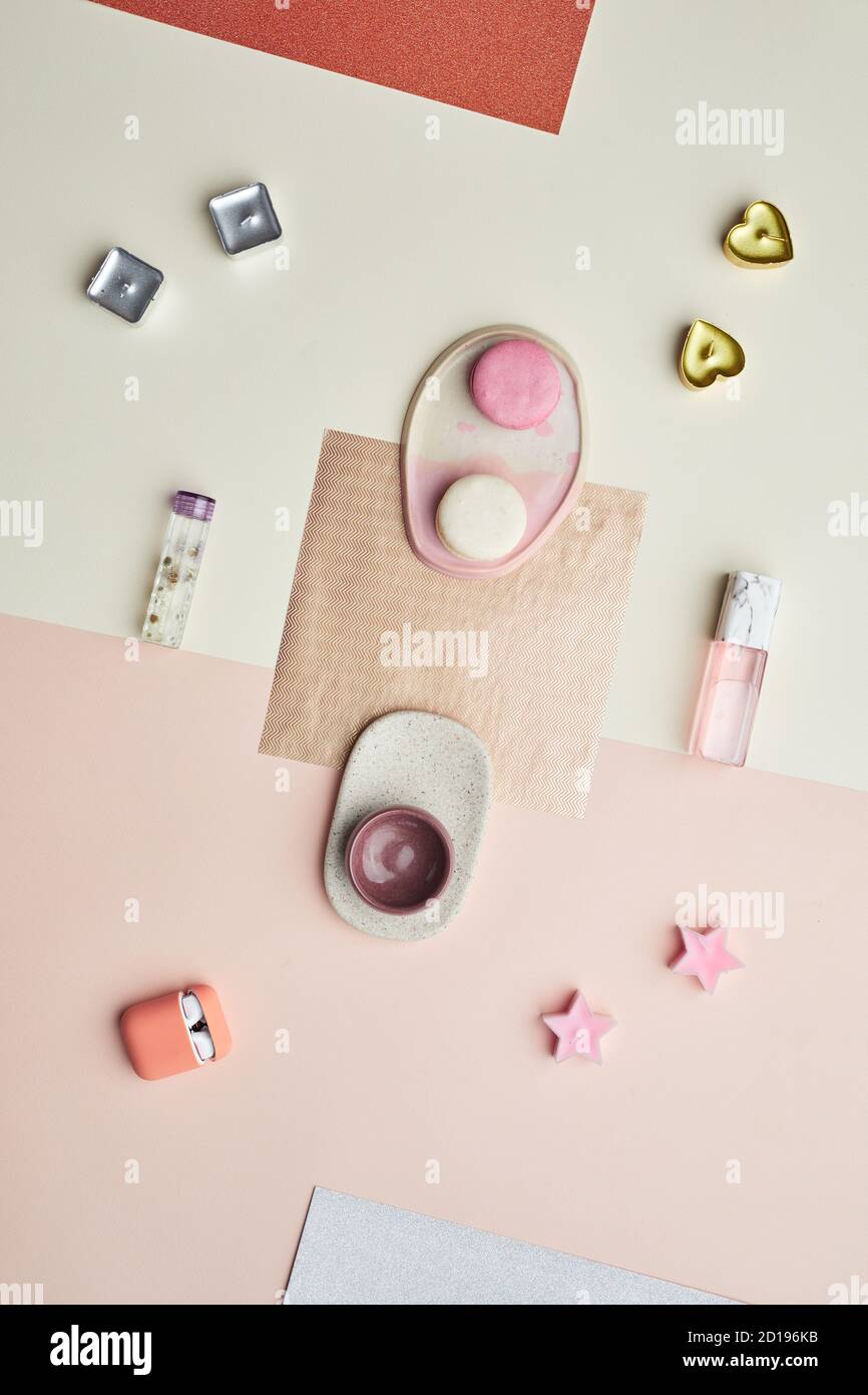 Image d'arrière-plan minimale des objets de couleur pastel rose écouteurs et bouteille de parfum disposés dans la composition graphique, l'espace de copie Banque D'Images