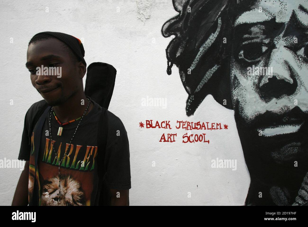 Un Homme Portant Un T Shirt Bob Marley Se Dresse Devant Une Fresque Murale Au Rasta Village De Port Bouet A Abidjan Le 8 Mai 10 Tandis Que D Autres West Africains S Eprennent A La Un Homme Portant Un T Shirt Bob Marley Se Dresse Devant Une Fresque Murale Au Rasta Village De Port Bouet A Abidjan Le 8 Mai 10 Tandis Que D Autres West Africains S Eprennent A La