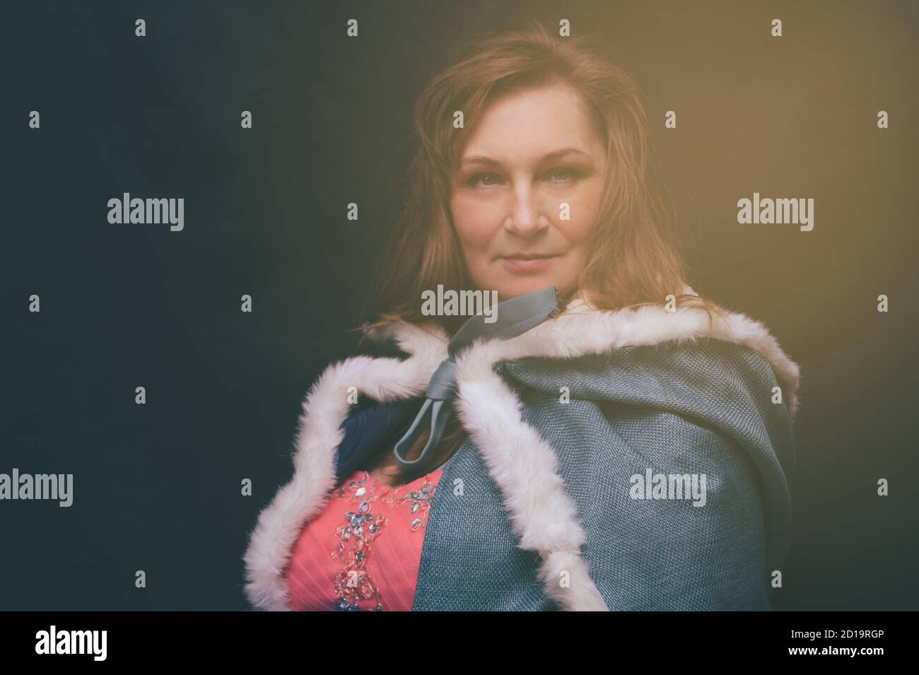 Femme en costume de reine avec manteau. Portrait de fantaisie artistique de femme adulte en robe royale sur fond noir Banque D'Images