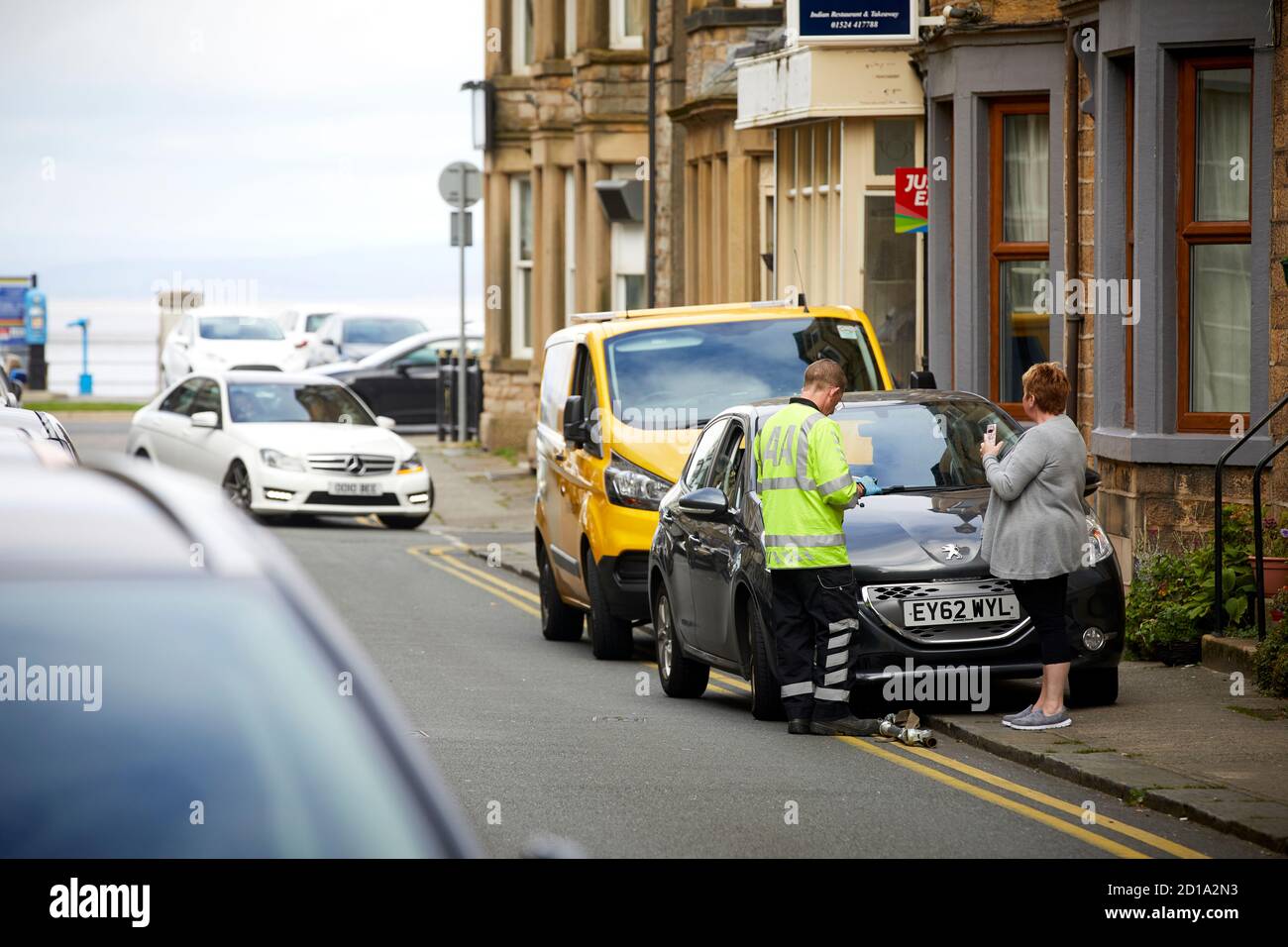 Morecambe Bay Lancashire la panne AA récupérer aider le conducteur D'une voiture Peugeot en panne Banque D'Images