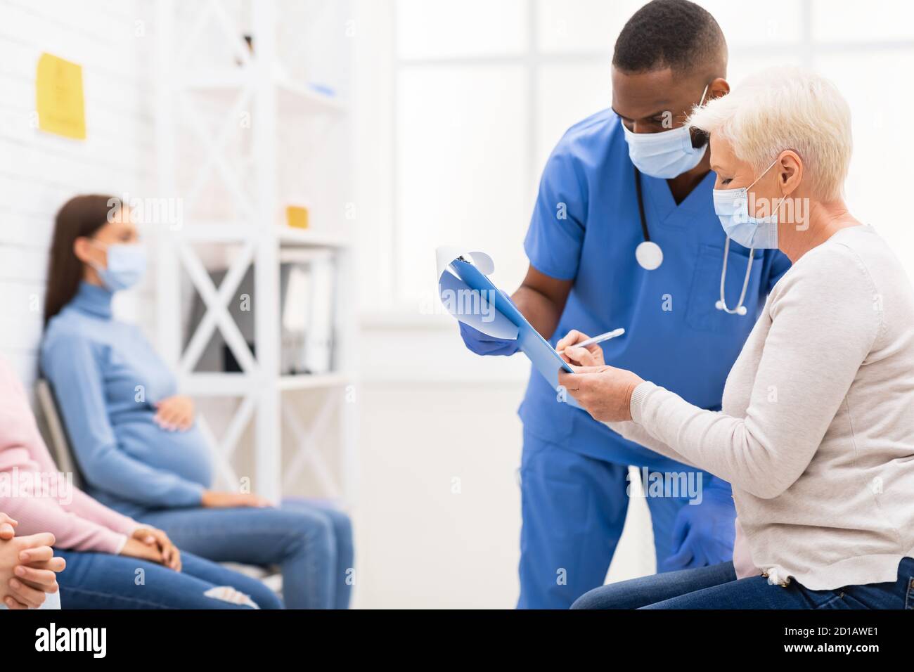 Papiers de signature de la patiente adulte avec le médecin en salle d'attente de l'hôpital Banque D'Images