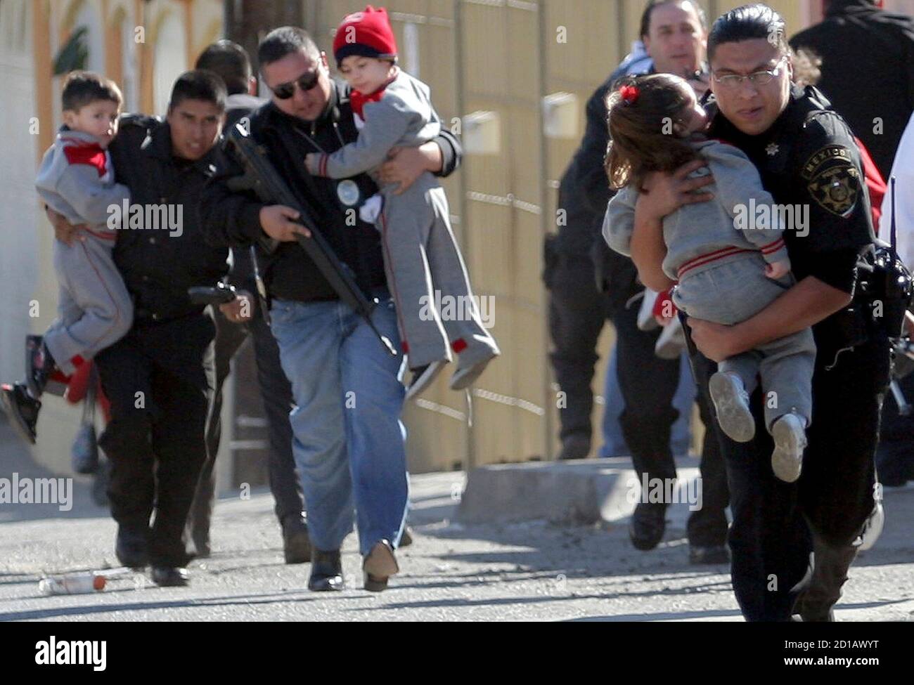 Police officers carry children away during a gun battle in Tijuana, in  Mexico's state of Baja California, January 17, 2008. A shootout on  Thursday, after police agents moved in on a drug