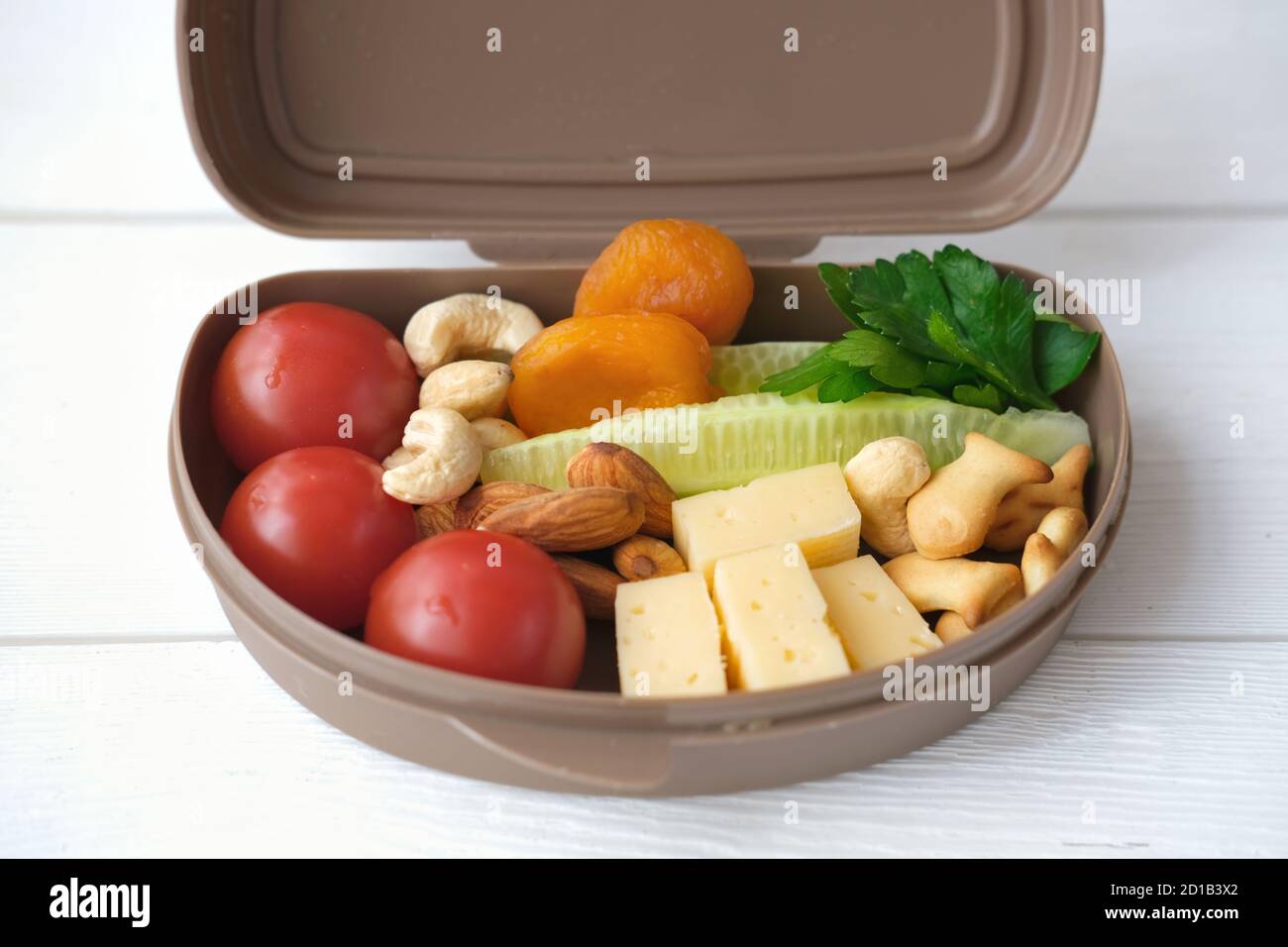 Concept de retour à l'école. Panier repas sain avec fromage, tomates, concombre et noix. Déjeuner scolaire pour les amateurs de pêche. Vue rapprochée Banque D'Images