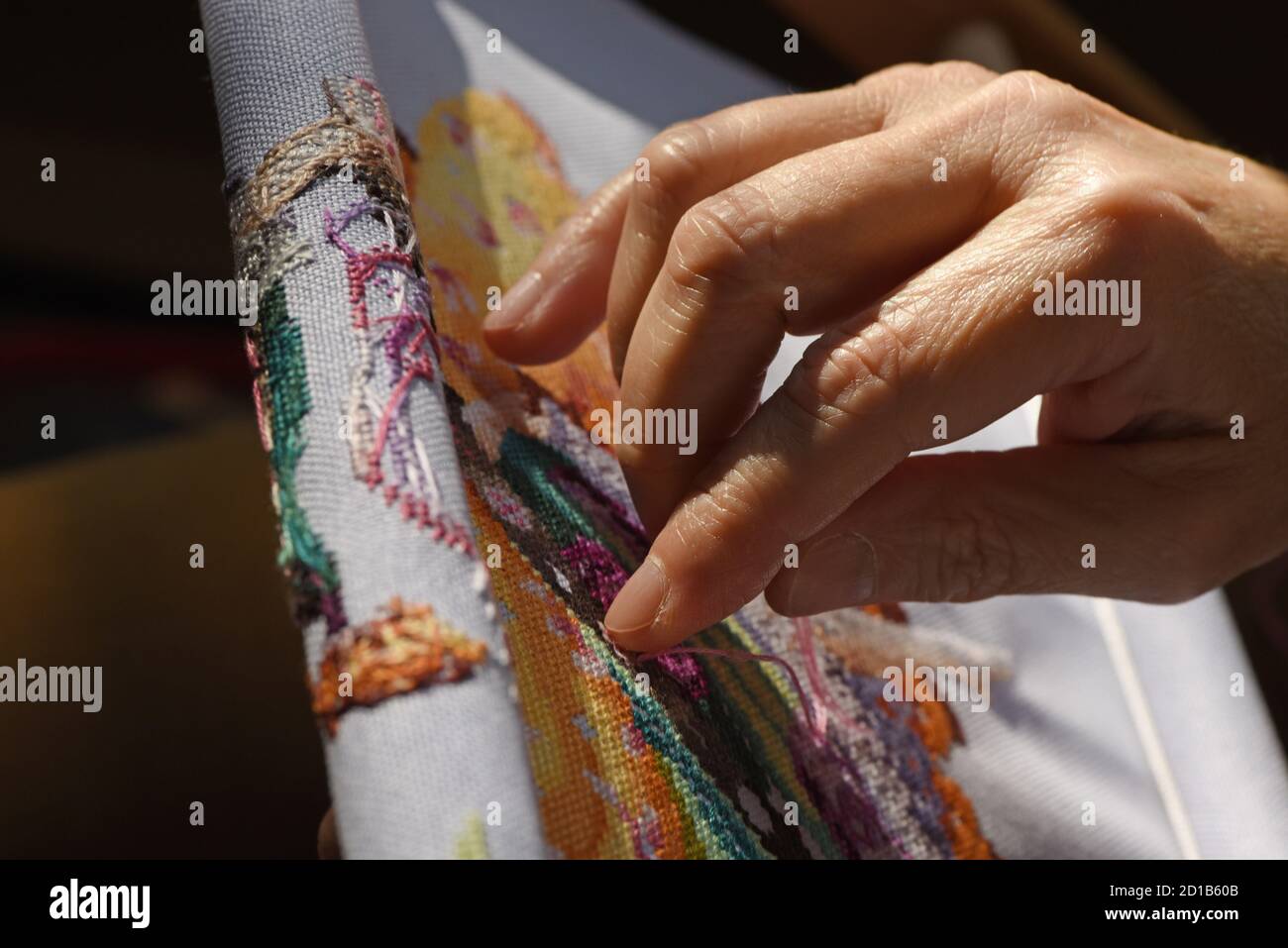 Une femme traverse un motif de point de croix de Miribilia sur un tissu à tissage de evenwey Banque D'Images