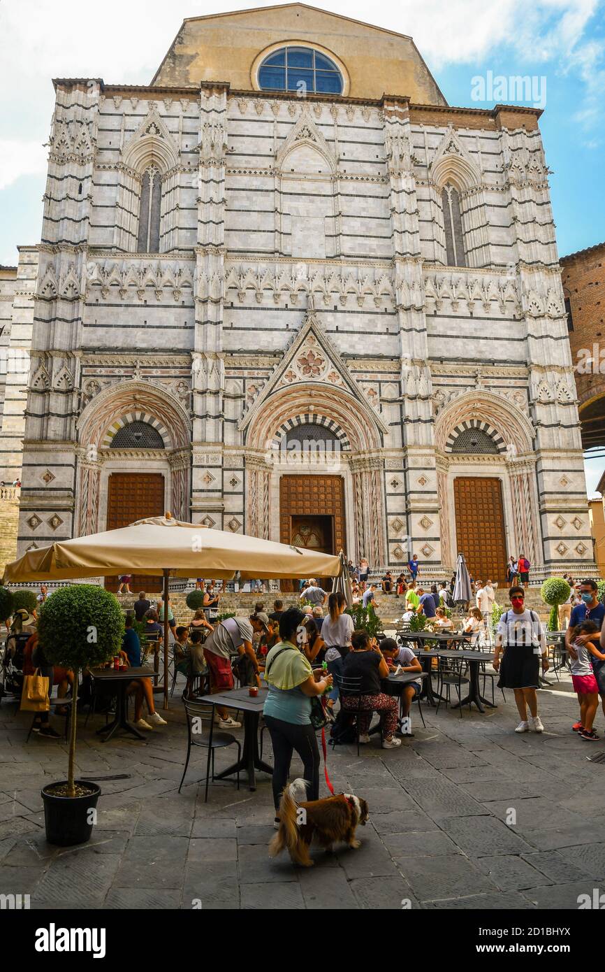 Façade du Baptistère de Saint-Jean dans le centre historique de Sienne, site classé au patrimoine mondial de l'UNESCO, avec des gens et des touristes en été, Toscane, Italie Banque D'Images