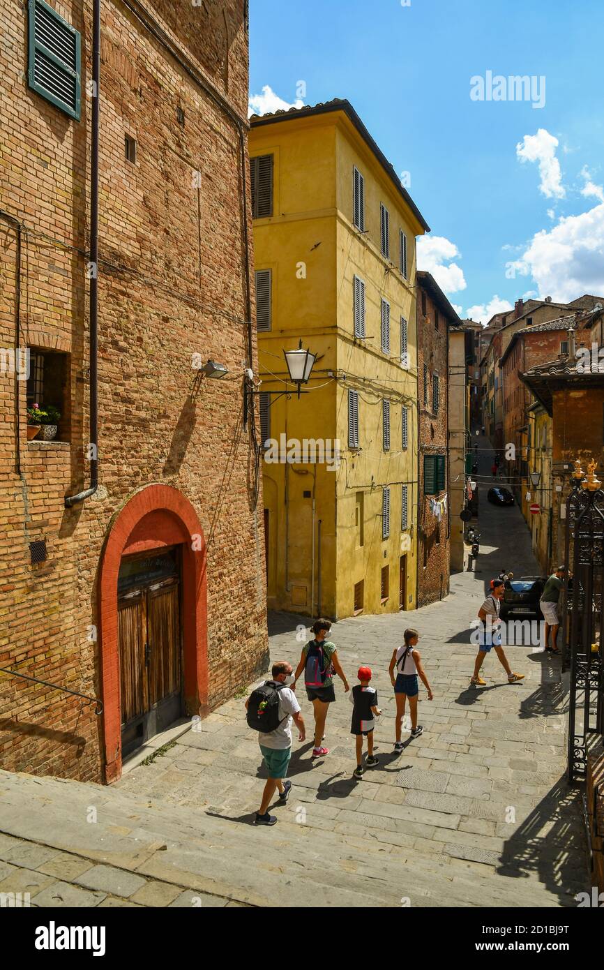 Vue panoramique sur la Costa Sant'Antonio, une ruelle étroite dans le centre historique de Sienne, UNESCO W.H. Site, avec des touristes en été, Toscane, Italie Banque D'Images