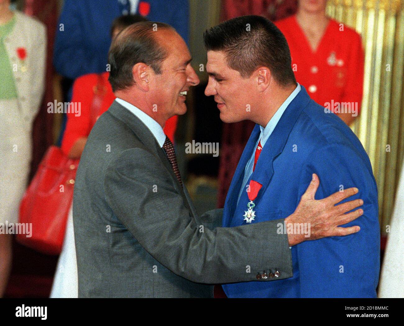 French President Jacques Chirac (L) embraces David Douillet (L), France's  Judo heavyweight gold medalist, after awarding him the Legion of Honour  medal at the Elysee Palace, September 6. France who won 15