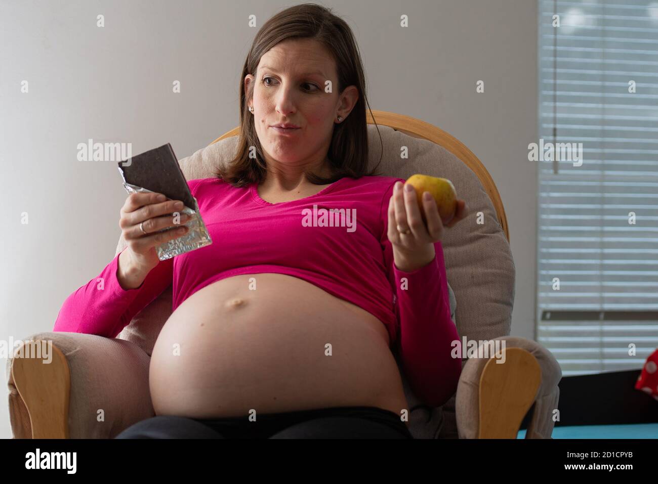 Jeune femme enceinte avec un gros ventre gonflé décidant entre un ...