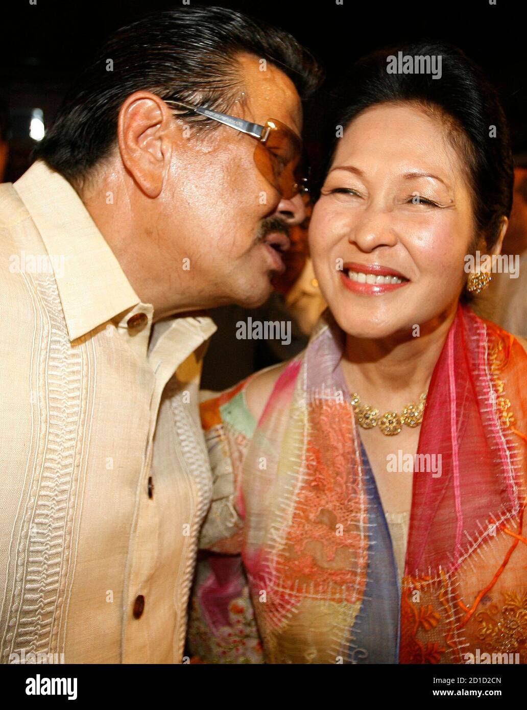 Former Philippines President Joseph Estrada kisses Guia Gomez as they