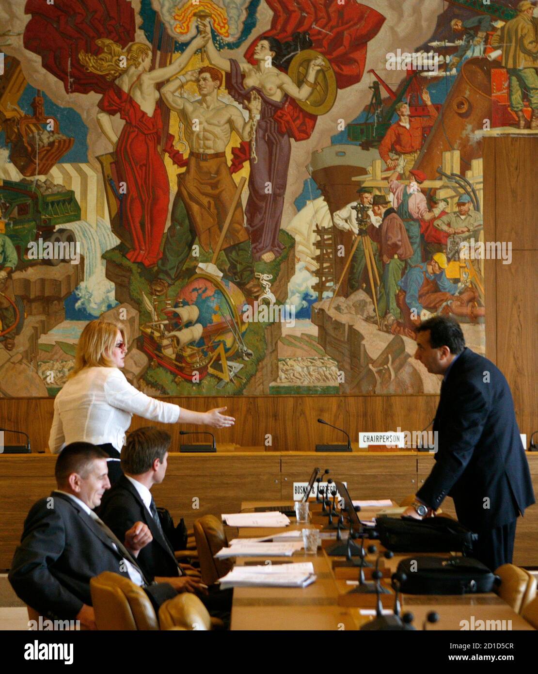 Unidentified delegates talk in front of a Dean Cornwell mural painting made  in 1938 in a meeting room at the World Trade Organization (WTO)  headquarters in Geneva July 18, 2008. As ministers