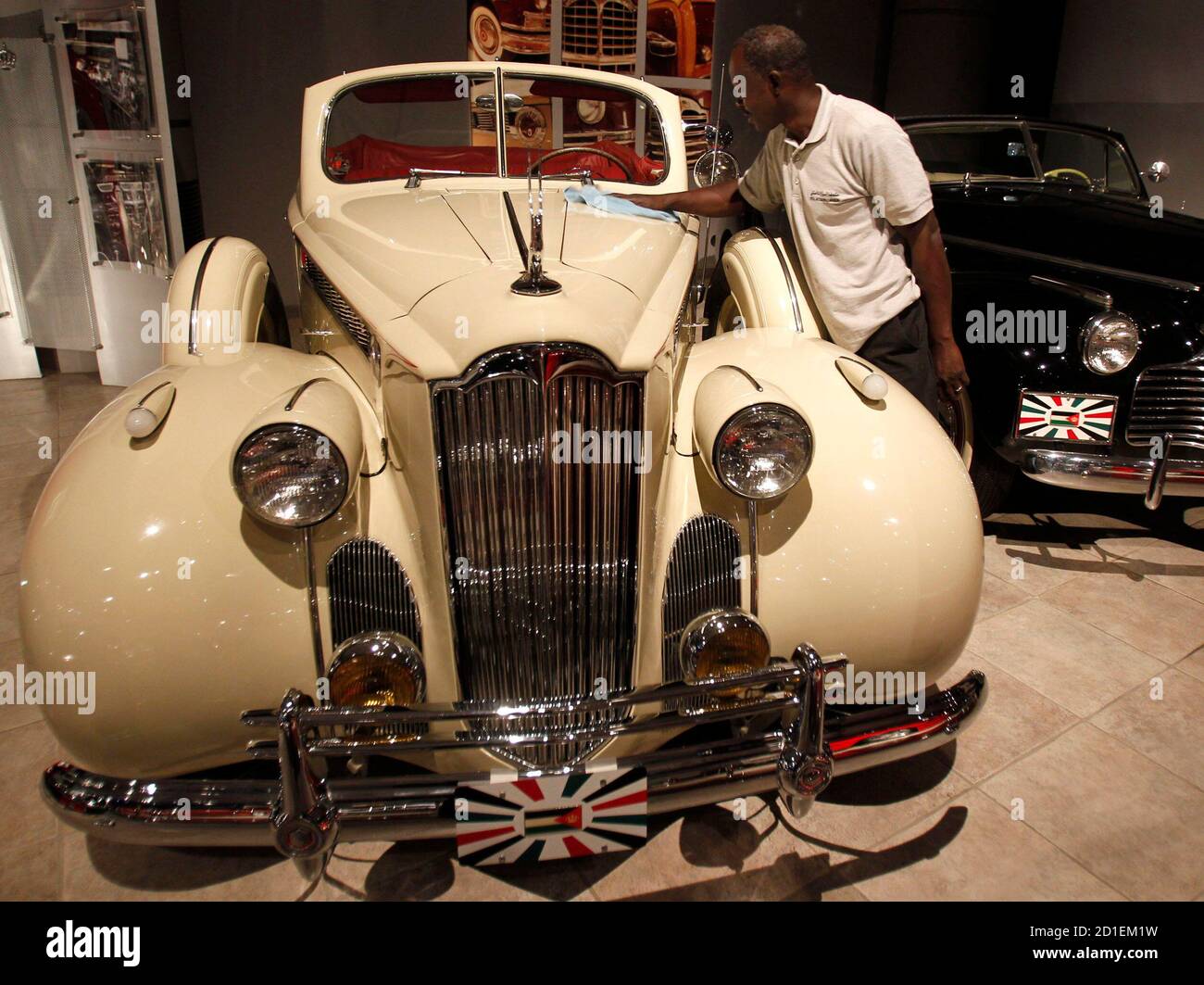 Un ouvrier nettoie un 1940 Packard super 8 appartenant à feu le roi Hussein jordanien et exposé avec d'autres voitures au Musée royal de l'automobile à Amman le 18 juillet 2010. REUTERS/Ali Jarekji (JORDANIE - Tags: TRANSPORT ROYALS SOCIETY) Banque D'Images