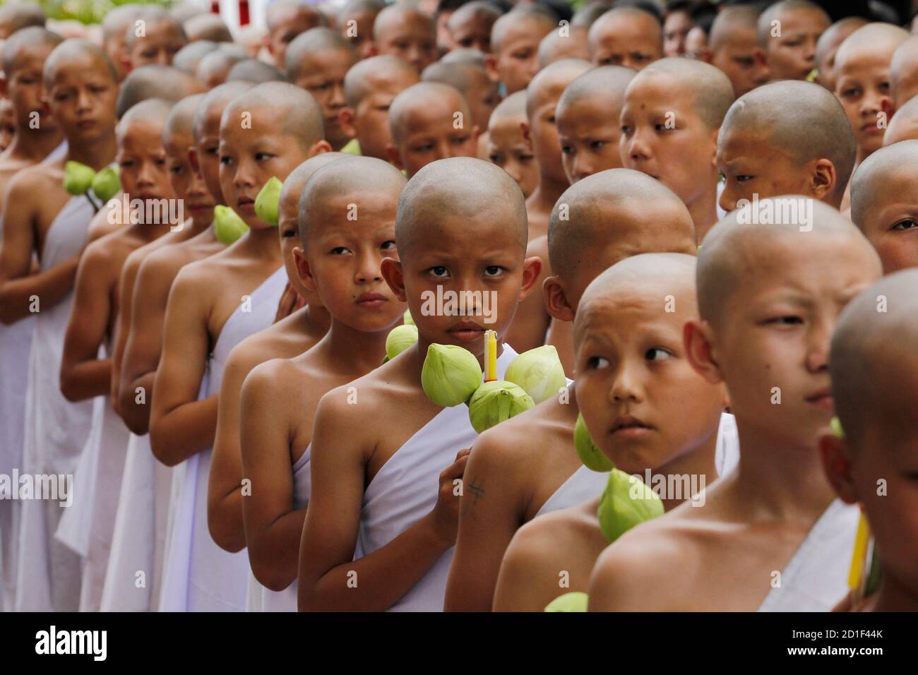 Young Thai hill tribesmen walk towards Wat Benchamopit, also known as the  Marble Temple, before a mass ordination, in Bangkok July 18, 2010. About  300 boys will enter monkhood for a period