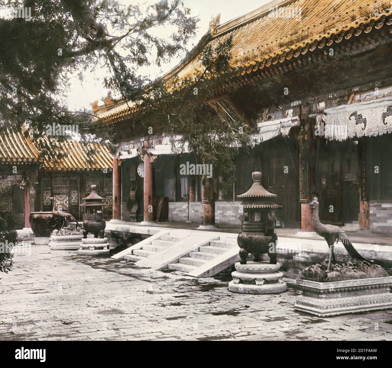 Vue colorisée des brûleurs d'encens et des statues d'oiseaux devant l'un des nombreux bâtiments de la Cité interdite, Pékin, Chine, 1901. (Photo de Burton Holmes) Banque D'Images