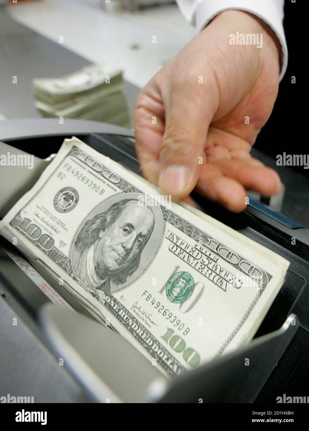 Un employé de la Korea Exchange Bank (KEB) compte des billets de cent dollars américains au siège de la banque à Séoul le 11 novembre 2008. REUTERS/JO Yong-Hak (CORÉE DU SUD) Banque D'Images