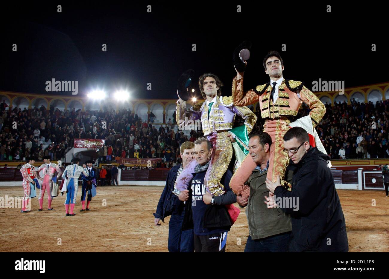 Spanish matadores Jose Tomas (C) and Miguel Angel Perera celebrate after  the end of a bullfight in Olivenza, near Badajoz March 6, 2010. Supporters  and opponents of bullfighting dueled in the Catalan