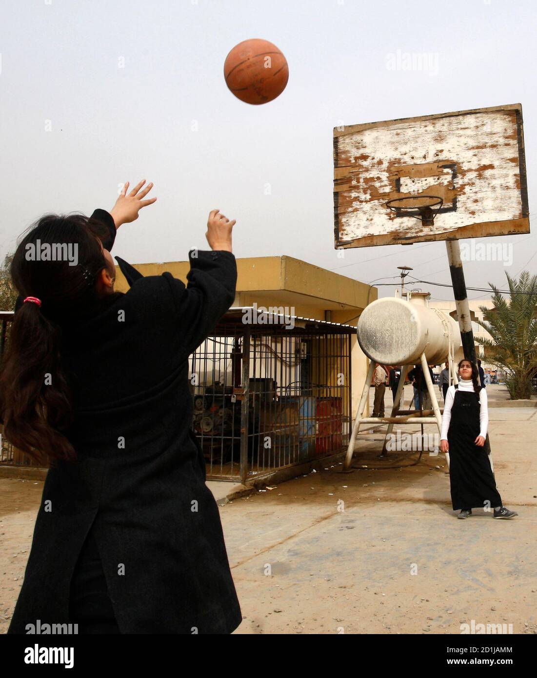 Les élèves jouent au basket-ball dans la cour de l'école secondaire Al-Motamayzat pour filles à Bagdad le 9 février 2009. Pour les écoles de Bagdad, Saddam Hussein, George W. Bush et l'abattage sectaire déclenché après l'invasion des troupes américaines il y a six ans sont des non-problèmes, interdits dans les livres et leur tabou de discussion. Photo prise le 9 février 2009. REUTERS/Thaier al-Sudani (IRAK) Banque D'Images