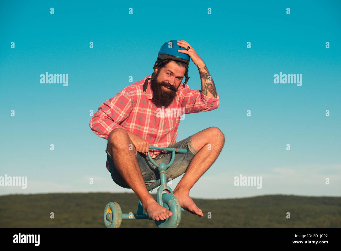 Guy tricycle d'équitation pour enfants. Vélo rider drôle. Comic man à vélo. Banque D'Images