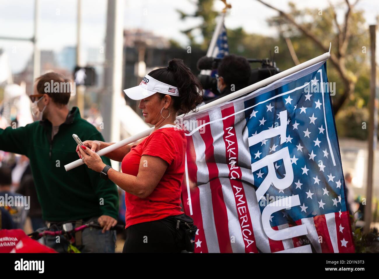 Bethesda, MD, États-Unis, 5 octobre 2020. Photo : les partisans de Trump se sont rassemblés devant le centre médical militaire national Walter Reed où il a été hospitalisé pour Covid-19. Beaucoup portaient des chapeaux et des vêtements Trump 2020 et/ou ont apporté des drapeaux. Cette femme a apporté un drapeau américain avec le nom et le slogan de Trump écrit à travers lui. Les fans du président se sont rassemblés pour montrer leur soutien pendant les quatre jours où il est resté à l'hôpital après avoir contracté le nouveau coronavirus. Crédit : Allison C Bailey/Alay Live News Banque D'Images Bethesda, MD, États-Unis, 5 octobre 2020. Photo : les partisans de Trump se sont rassemblés devant le centre médical militaire national Walter Reed où il a été hospitalisé pour Covid-19. Beaucoup portaient des chapeaux et des vêtements Trump 2020 et/ou ont apporté des drapeaux. Cette femme a apporté un drapeau américain avec le nom et le slogan de Trump écrit à travers lui. Les fans du président se sont rassemblés pour montrer leur soutien pendant les quatre jours où il est resté à l'hôpital après avoir contracté le nouveau coronavirus. Crédit : Allison C Bailey/Alay Live News Banque D'Images