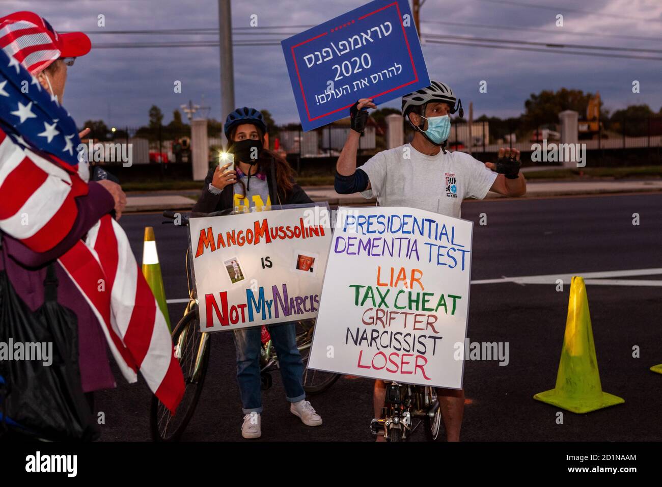 Bethesda, MD, États-Unis, 5 octobre 2020. Sur la photo : deux manifestants anti-Trump ont été accostés par des partisans de Trump et ont été agressés verbalement, mais cela ne les a pas dissuarés. Leurs signes ont appelé Trump un « menteur, tricheur fiscal, griffeur, narcissique et perdant », ainsi que « Mango Mussolini ». Cela a eu lieu pendant que les partisans de Trump se sont rassemblés devant le centre médical militaire national Walter Reed où il a été hospitalisé pour le covid-19 après avoir contracté le nouveau coronavirus. Crédit : Allison C Bailey/Alay Live News Banque D'Images