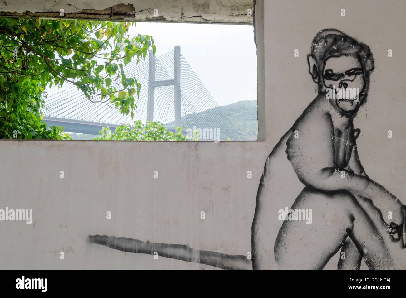 Graffiti dans un bâtiment abandonné à Ma WAN avec le pont en arrière-plan qui a été la raison de l'abandon forcé du village. Banque D'Images