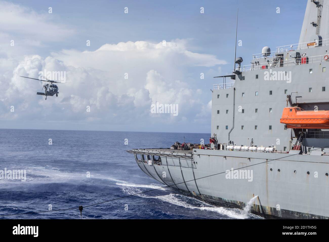 Un Faucon de mer MH-60S, affecté aux « Faucons d'or » de l'escadron de combat de la mer d'hélicoptère (HSC) 12, récupère les fournitures du Pecos de l'USNS (T-AO-197) au quai d'atterrissage amphibie USS Comstock (LSD 45) le 3 septembre 2020. Comstock est déployé dans l'océan Pacifique et conduit des opérations maritimes de routine. La Force opérationnelle Ellis, compromise de Marines et de marins de I Marine Expeditionary Force, a été déployée à bord de l'USS Comstock (LSD 45) dans l'Indo-Pacifique pour mener des activités de coopération en matière de sécurité dans le théâtre de juillet à novembre 2020. Tout le personnel de la Force opérationnelle Ellis à bord de l'USS Comstock a été COVID-1 Banque D'Images